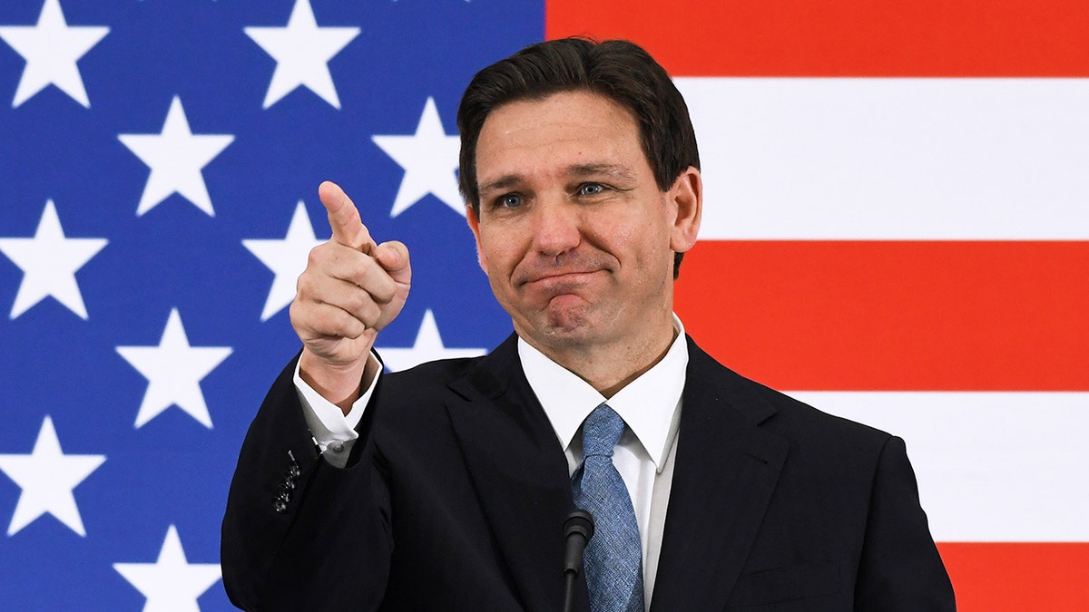 DeSantis pointing with an American flag in the background