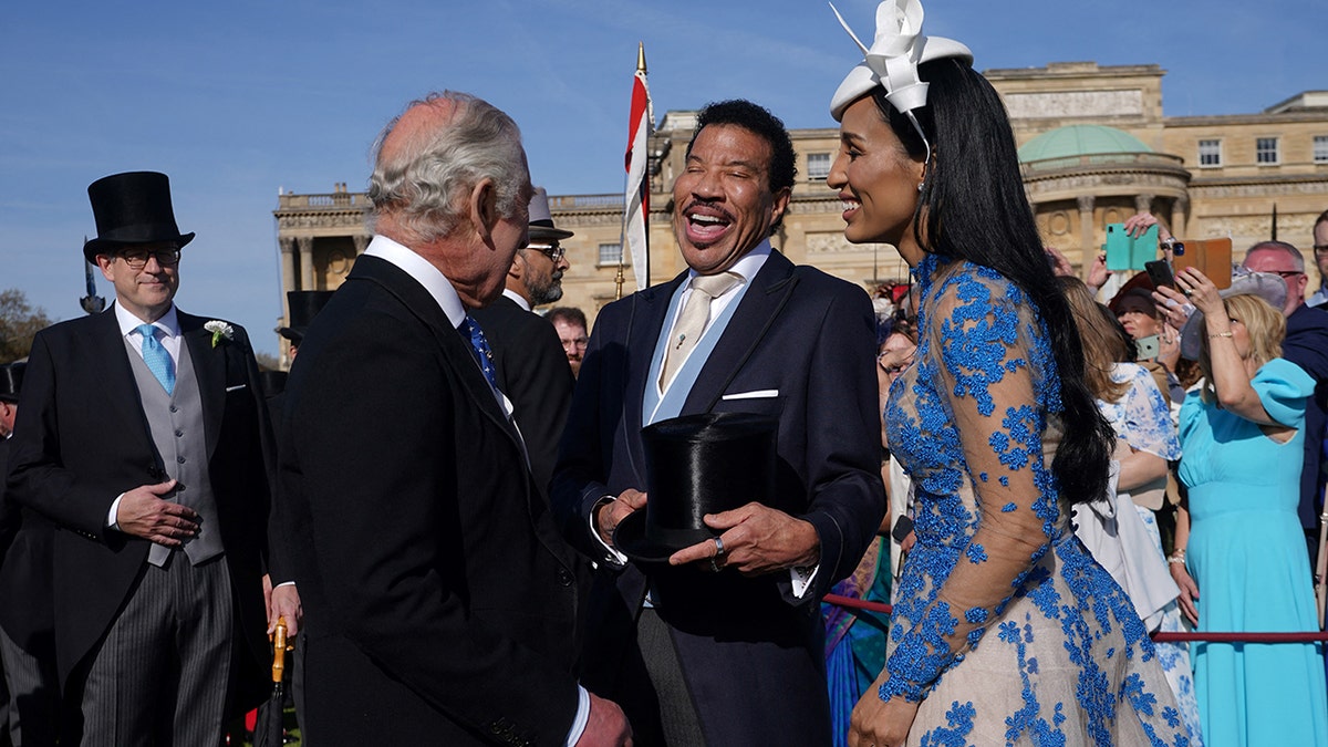 King Charles with his back to the camera shares a laugh with Lionel Richie and his girlfriend Lisa Parigi at the Garden Party at Buckingham Palace ahead of the coronation