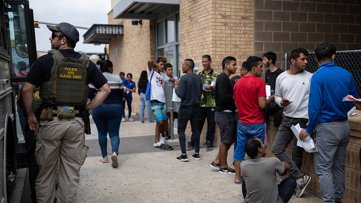 Migrants in a line near a bus in Texas