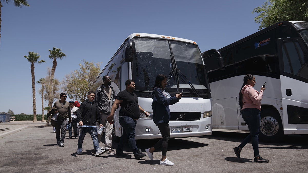 Migrants board bus in Yuma