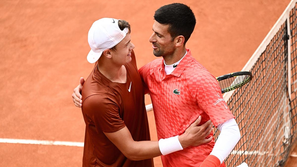 Holger Rune and Novak Djokovic shake hands ay center court after their quarterfinal match