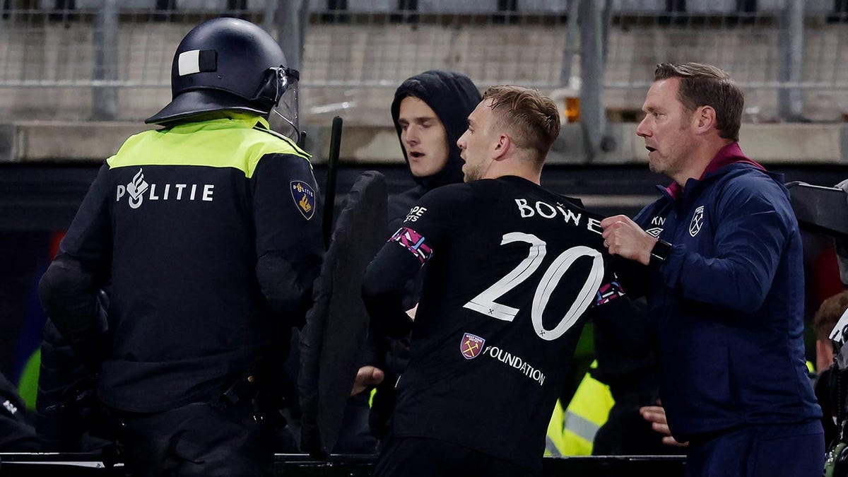 A West Ham United player is held back during a brawl in the stands