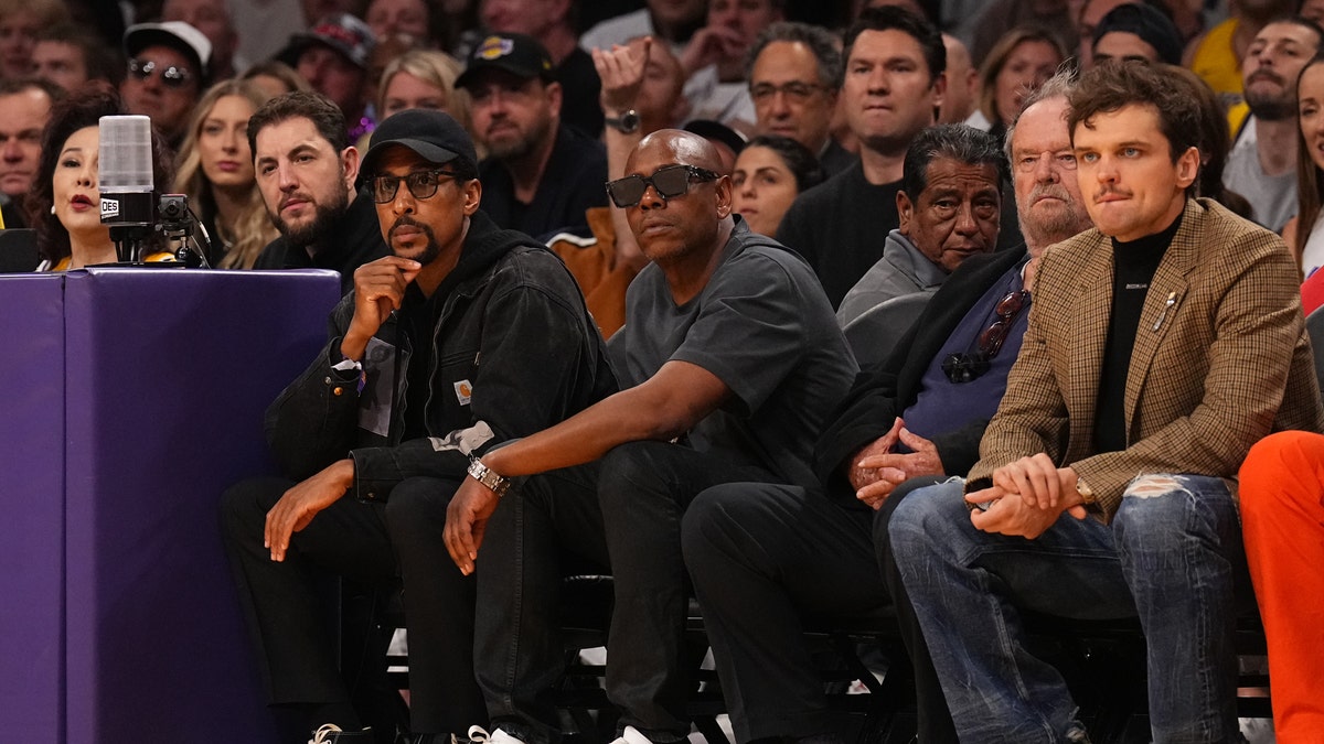 Dave Chappelle wears sunglasses next to Jack Nicholson and his son Ray Nicholson at Lakers game
