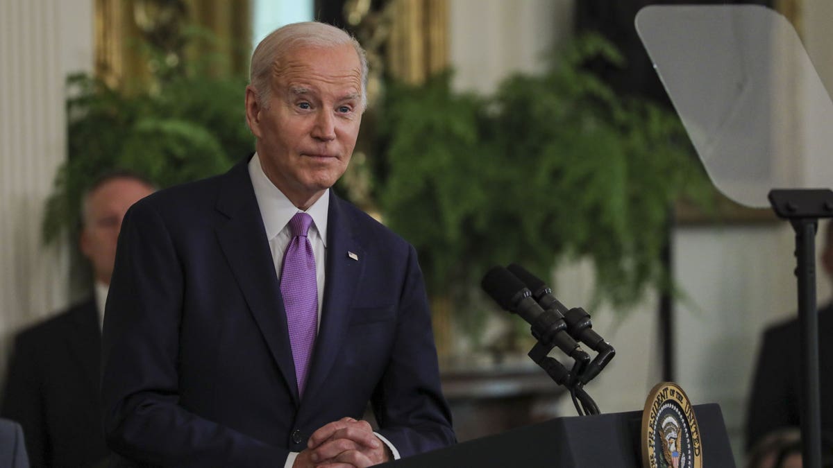 Joe Biden is wearing a purple suit and tie