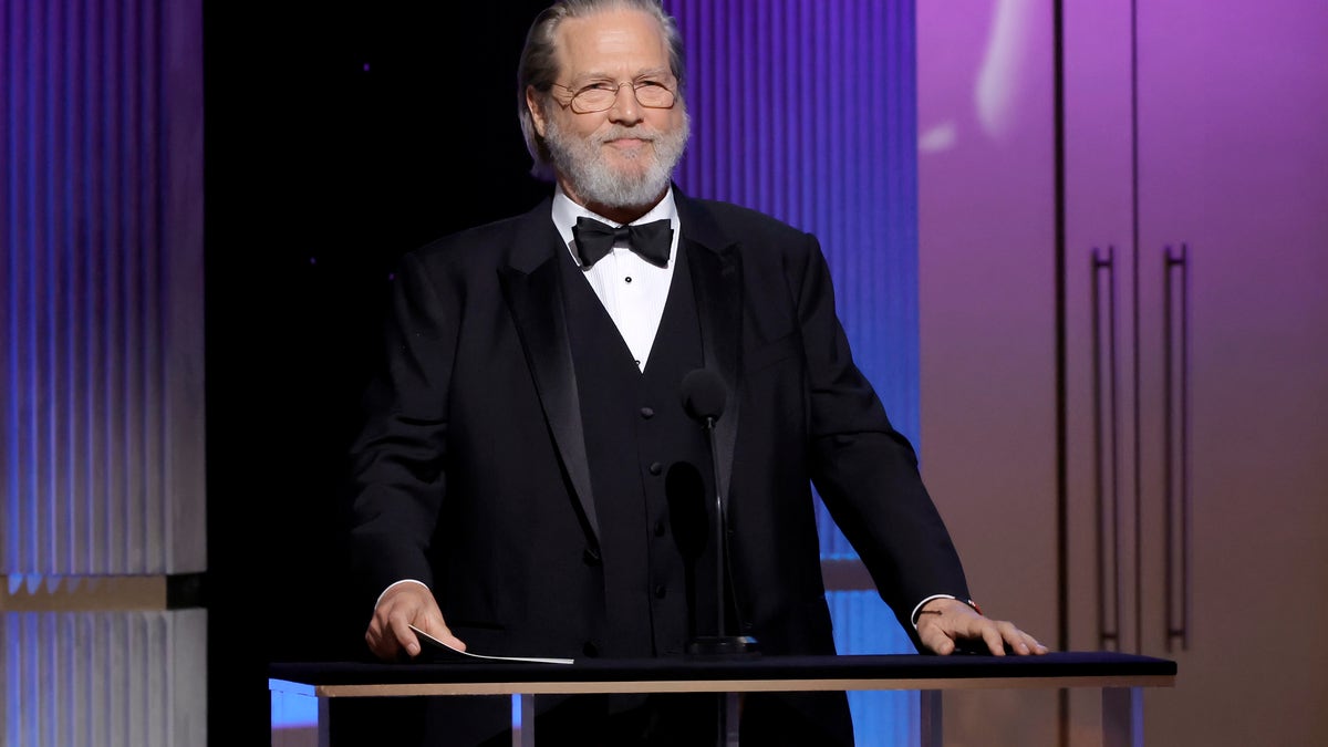 Jeff Bridges at a podium in a tuxedo.