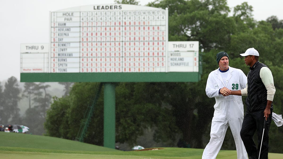 Tiger Woods and Joe LaCava walk the green at Augusta National