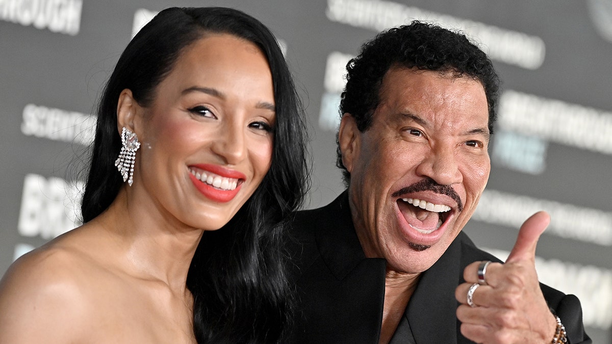 萊昂內爾·里奇(Lionel Richie)在紅地毯上微笑,同時在第9屆年度突破頒獎典禮旁邊拋光拇指