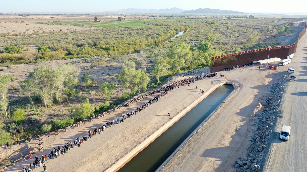 Immigrants seeking asylum in the U.S. wait after crossing into Arizona from Mexico on May 11, 2023.