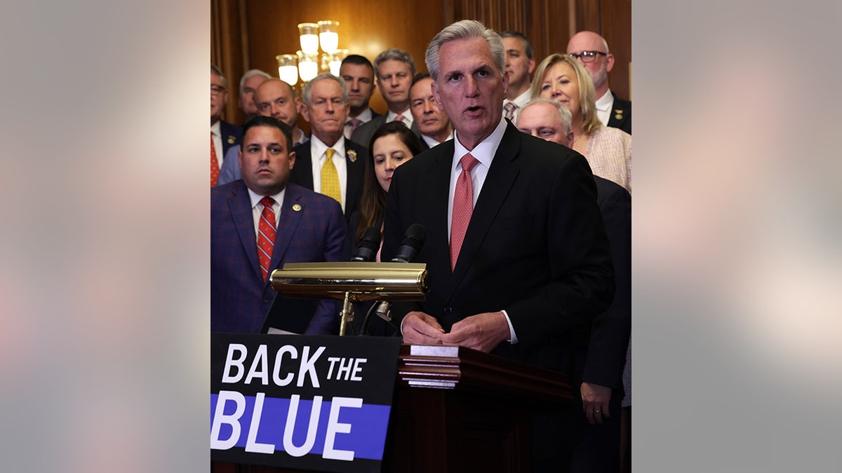 House Speaker McCarthy by Back the Blue sign 