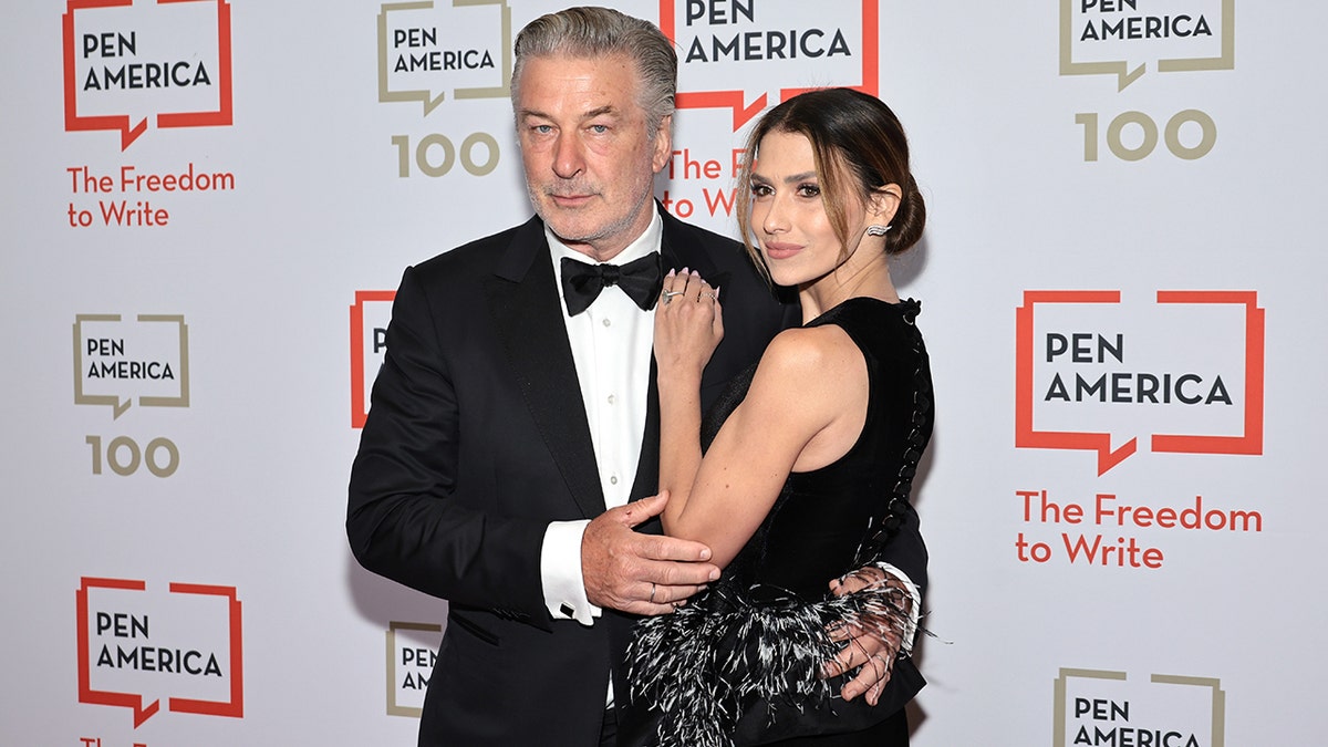 Alec Baldwin in a classic tuxedo holds onto wife Hilaria in a black outfit, while attending the PEN America Literary Gala