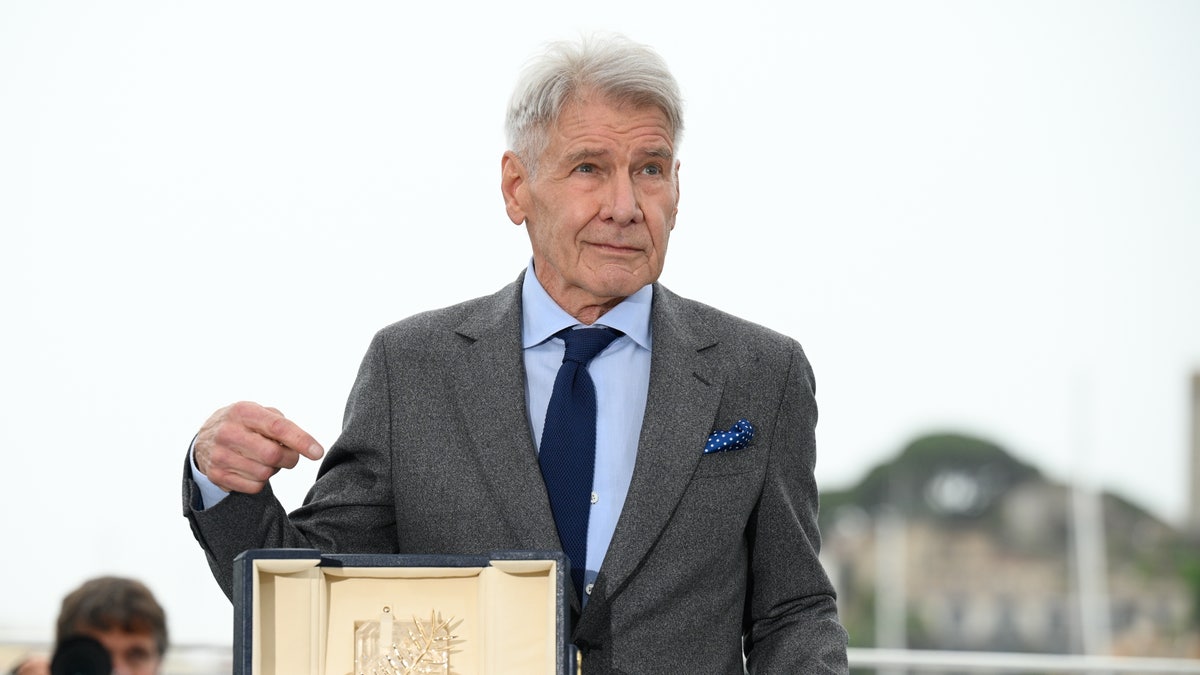 Harrison Ford pointing at his Palme D'Or award in Cannes