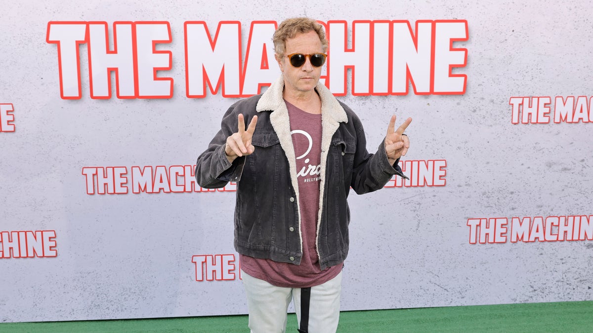 Pauly Shore gives the peace sign on the carpet at The Machine premiere