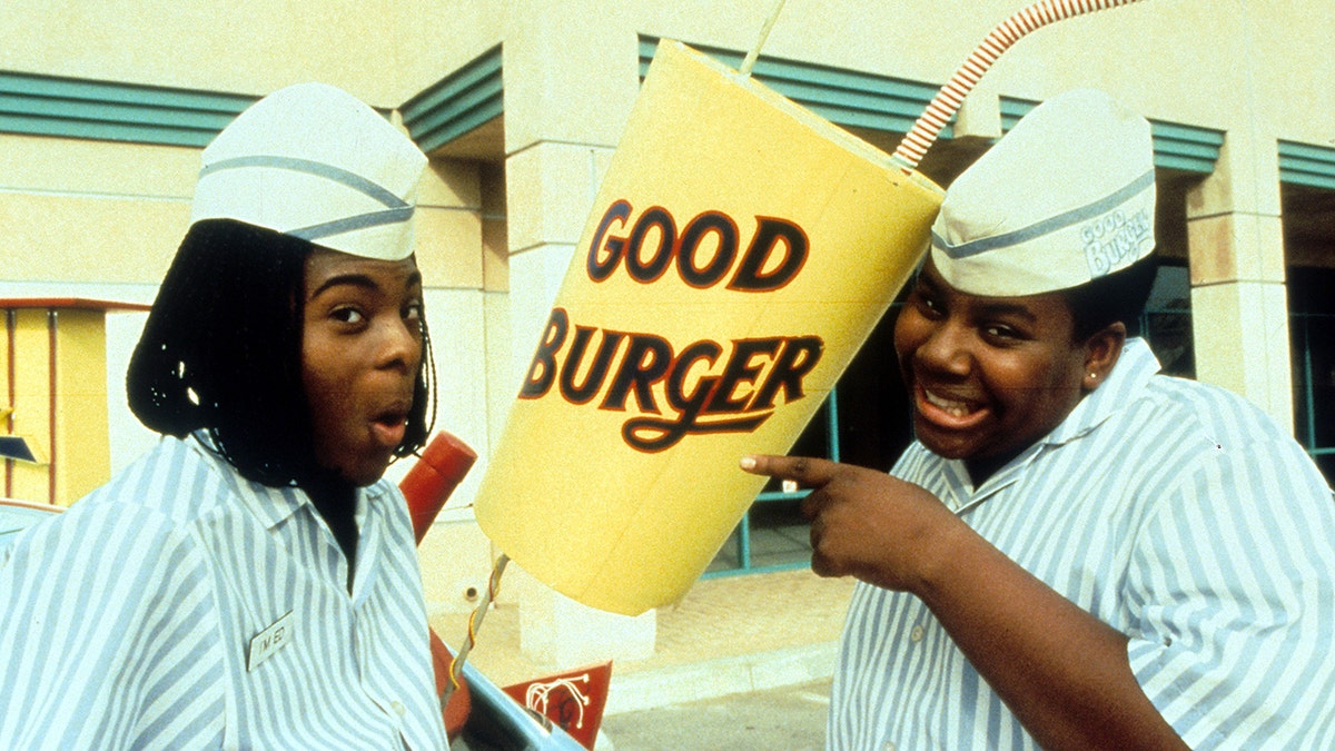 Kel Mitchell and Kenan Thompson pose in their Good Burger uniforms holding a massive shake from their film 'Good Burger'