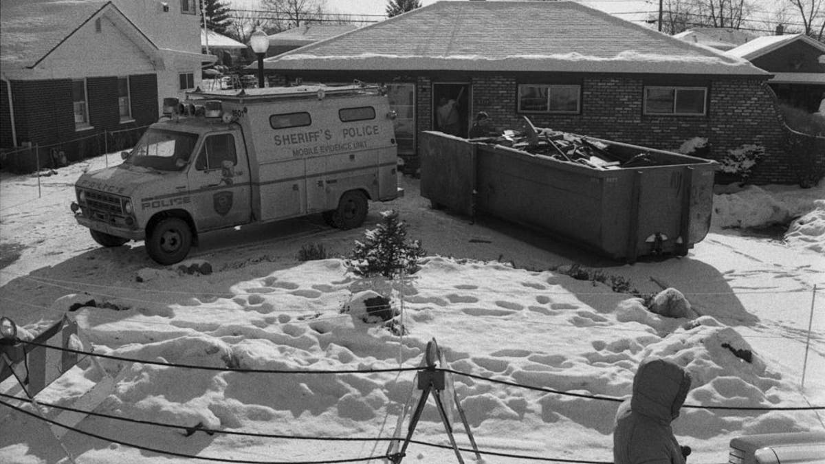 Police vehicle and dumpster outside John Wayne Gacy's house