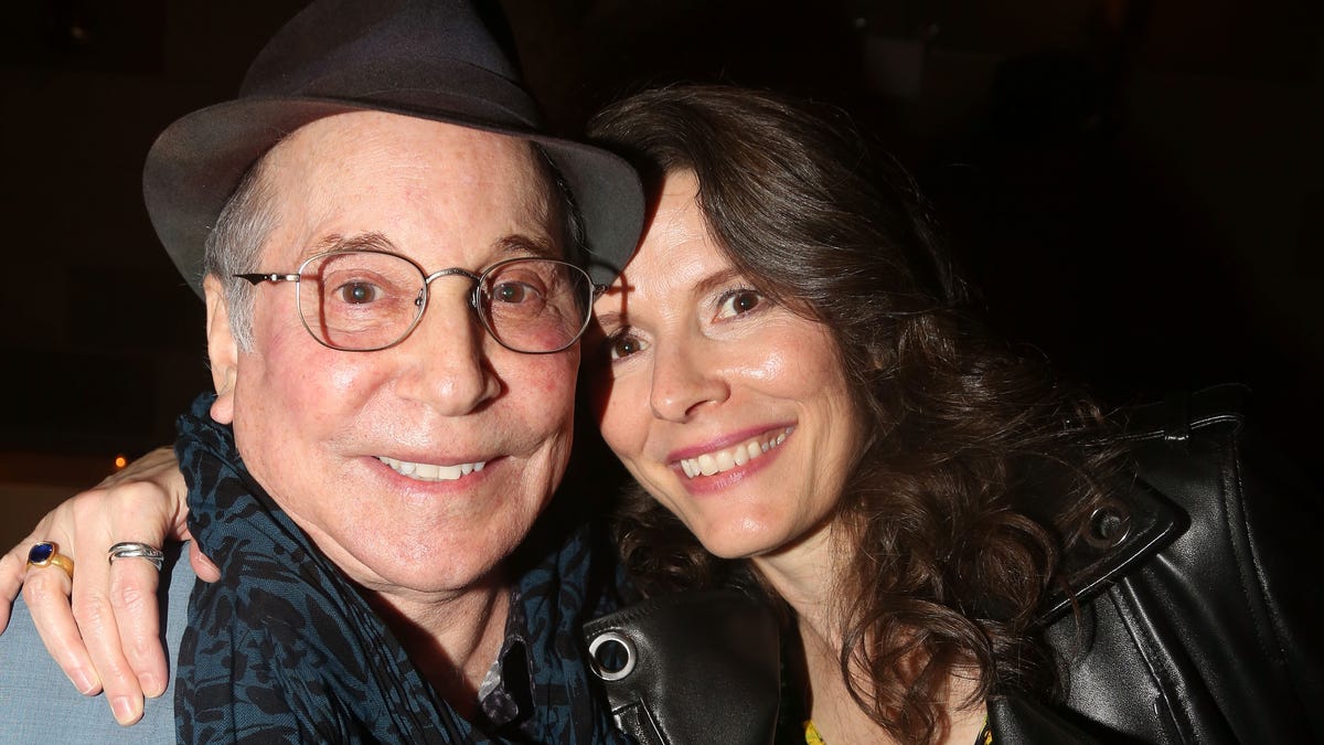 Paul Simon and wife Edie Brickell smiling in close up