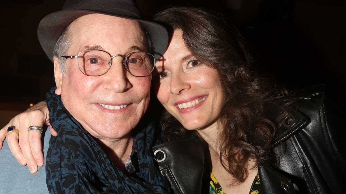 Paul Simon and wife Edie Brickell smiling in close up