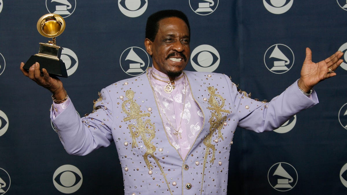 Ike Turner in a purple suit holding his grammy