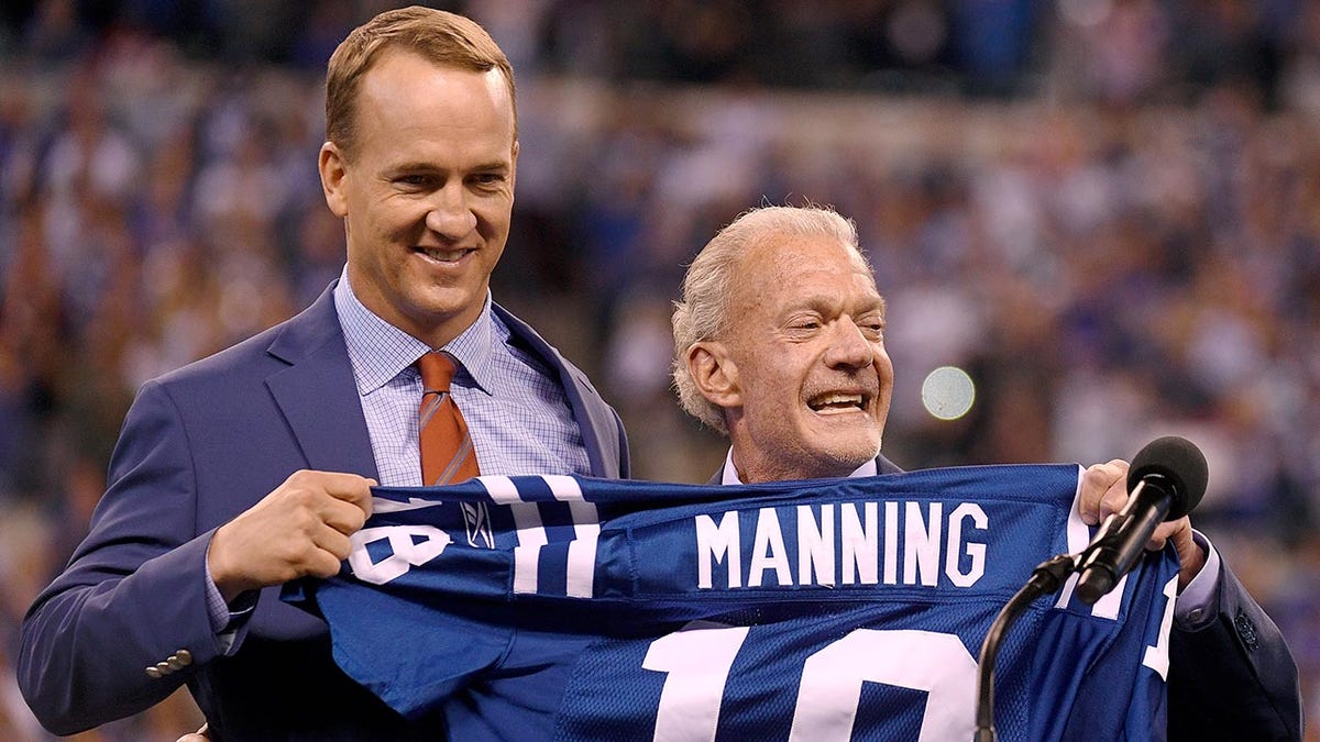 Peyton Manning stands with Colts owner Jim Irsay at his jersey retirement ceremony