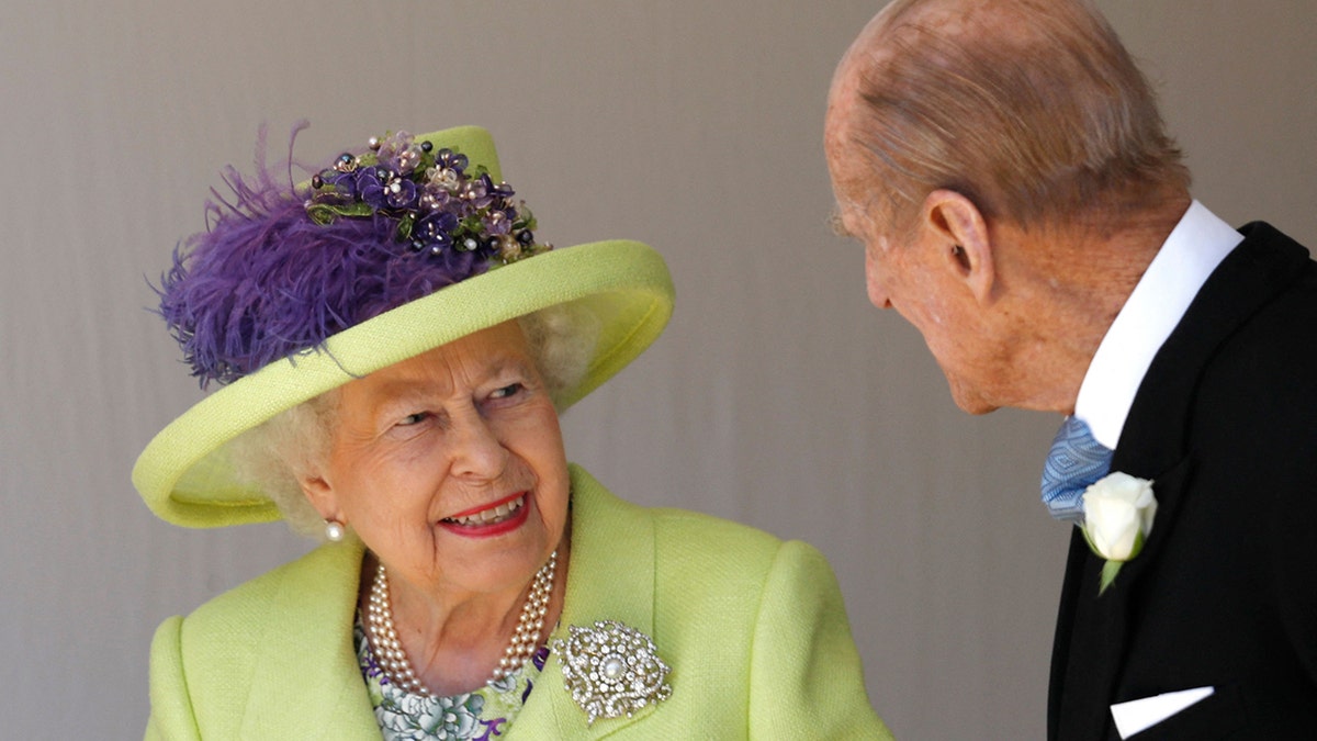 Queen Elizabeth smiles in a key-lime green jacket and matching hat at Prince Philip at Georges Chapel after the wedding between Prince Harry and Meghan Markle