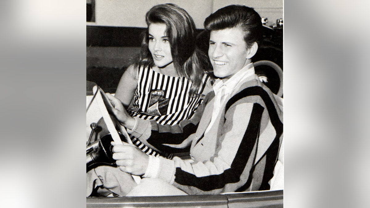 Bobby Rydell riding a car in a striped shirt next to Ann-Margret in a matching striped dress