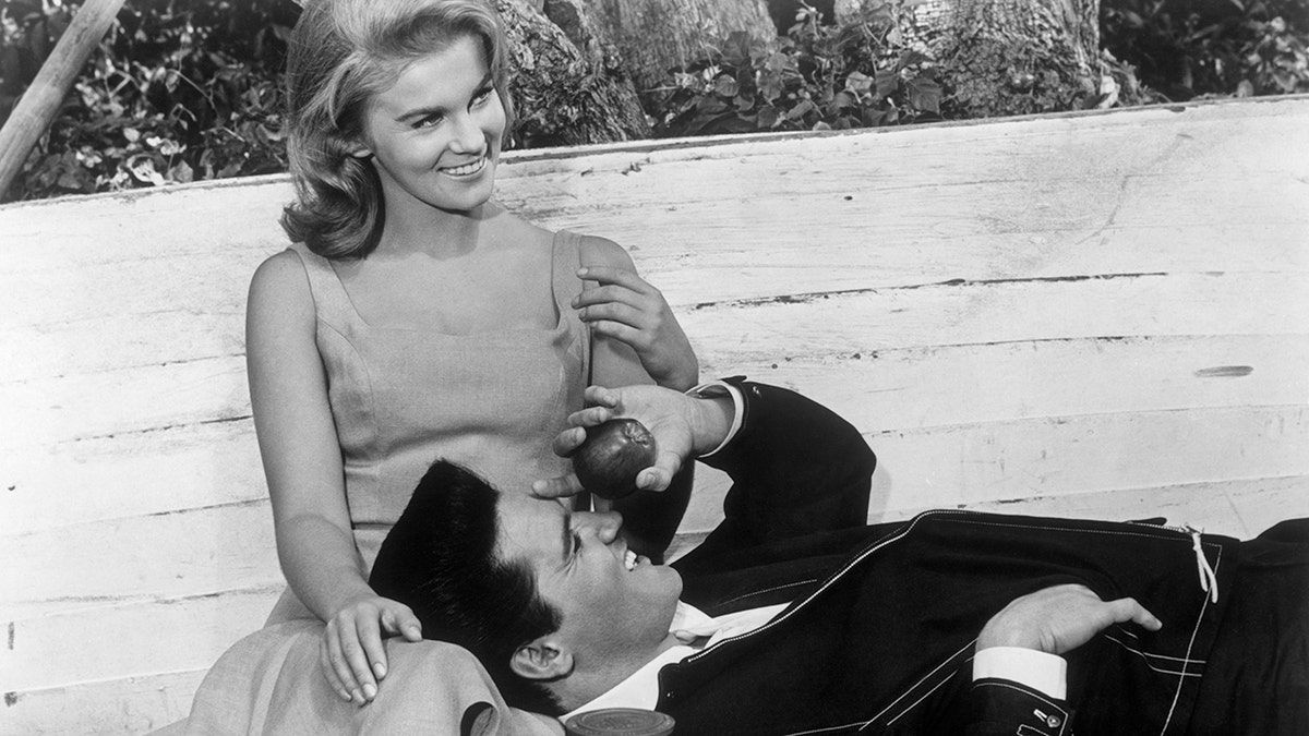 Elvis Presley smiling and laying on Ann-Margrets lap