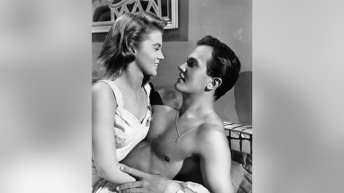 Ann-Margret in a white dress leaning against a shirtless Pat Boone