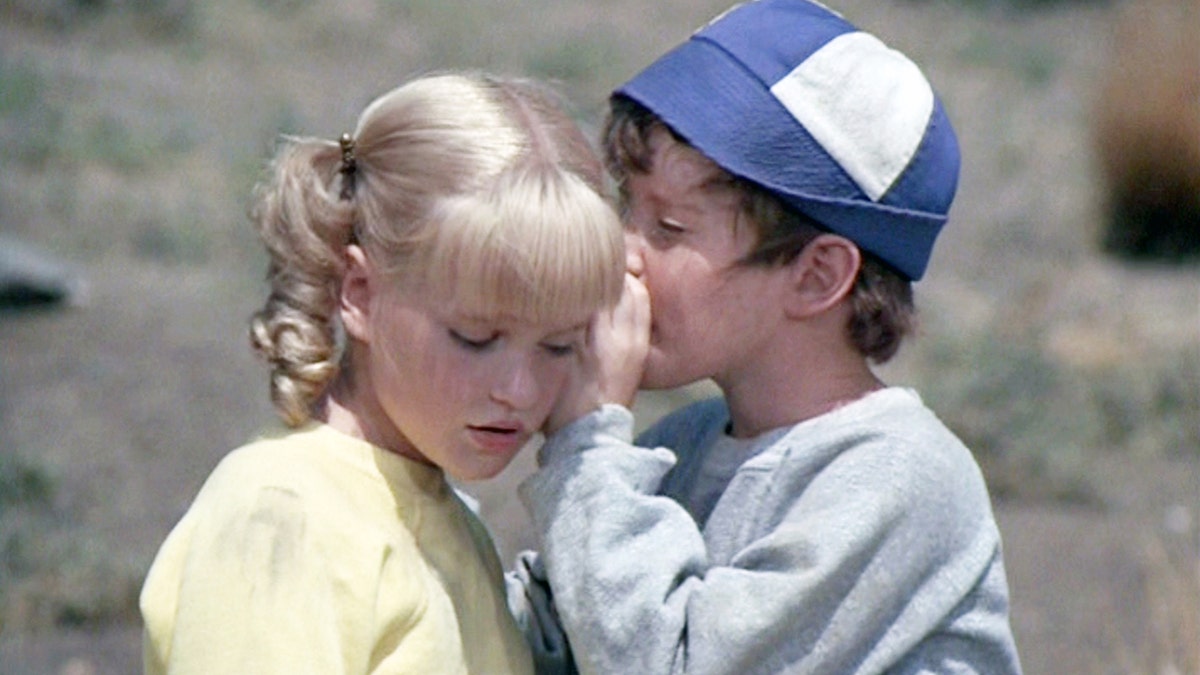 Mike Lookinland as Bobby Brady whispering in Susan Olsens ear, who is playing Cindy Brady