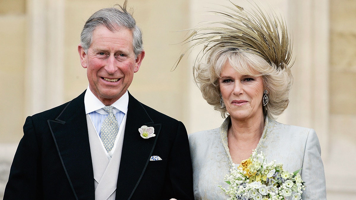 Prince Charles in a suit next to his bride Camilla wearing a bridal gown
