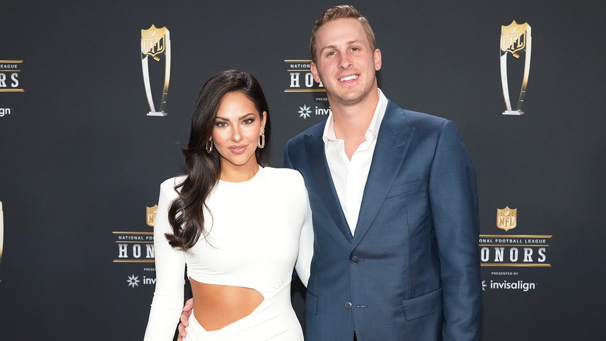 Christen Harper in a white cut-out dress with Jared Goff in a blue blazer and white shirt smiling at the NFL Honors