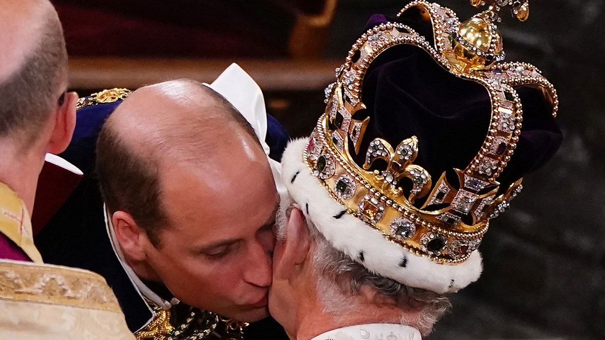 A close-up of Prince William kissing his father King Charles