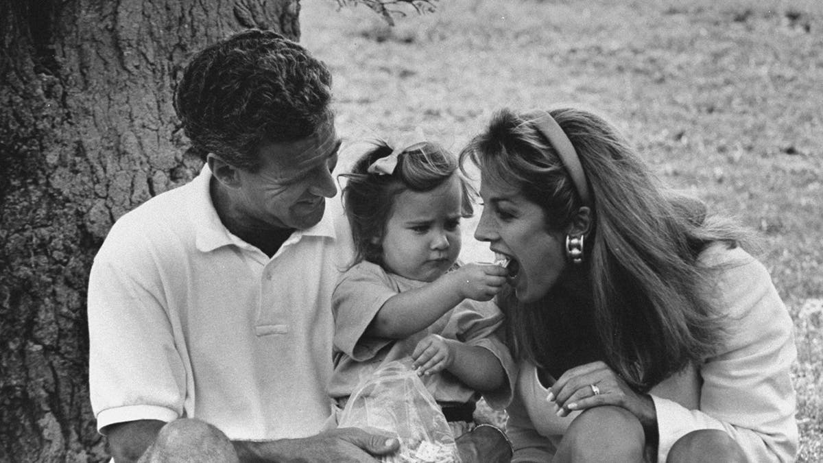 Denise Austin getting fed by her daughter in a black and white photo