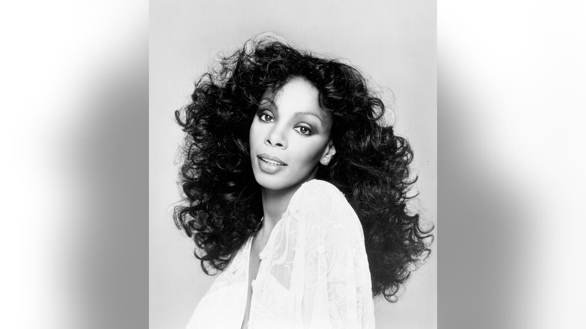 A black and white photo of donna summer wearing a white dress