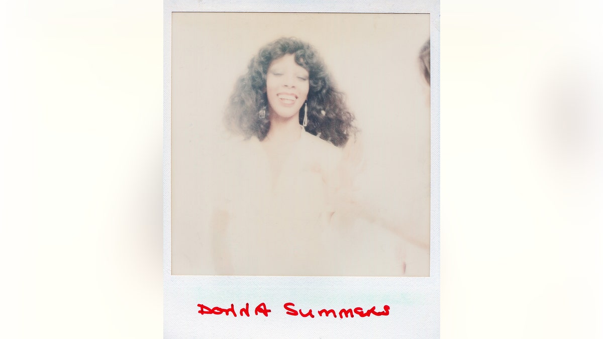 A polaroid of Donna Summer smiling in a hazy background