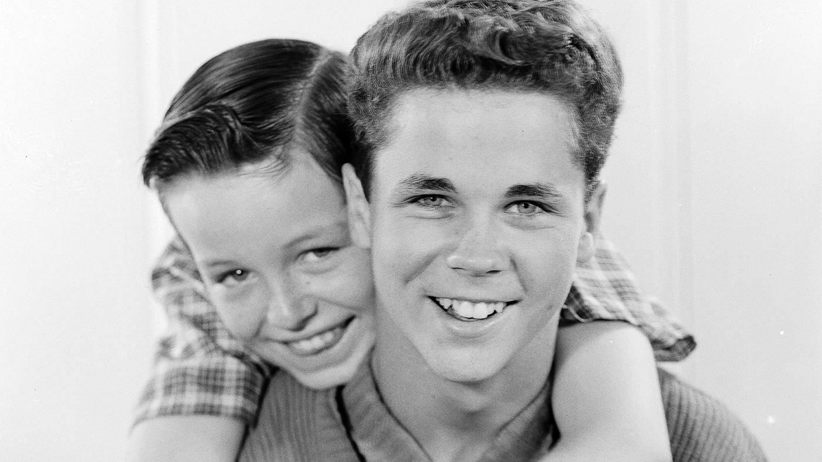 Jerry Mathers embracing Tony Dow in a close-up photo