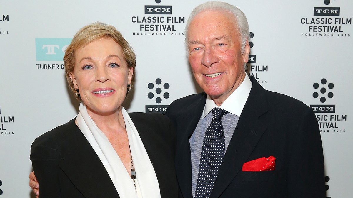 Julie Andrews and Christopher Plummer smiling while posing next to each other on the red carpet