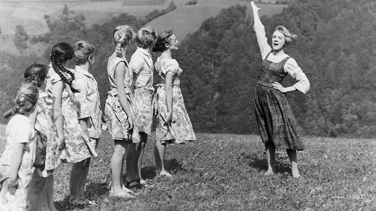 English actress and singer Julie Andrews as the young nun Maria, teaching the von Trapp children to sing