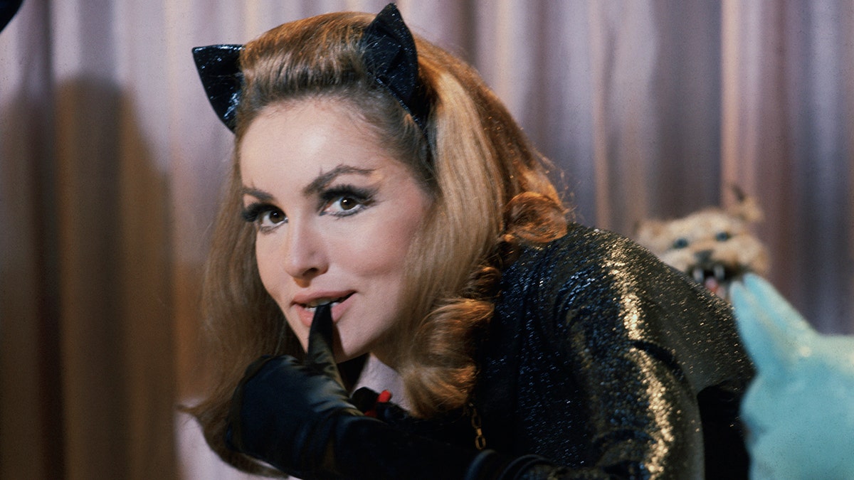 Julie Newmar biting her thumb in costume as Catwoman