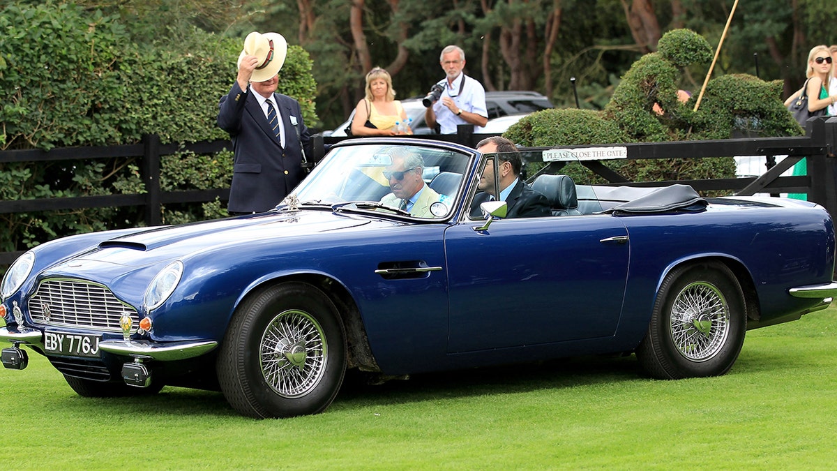 King Charles driving his Aston Martin car