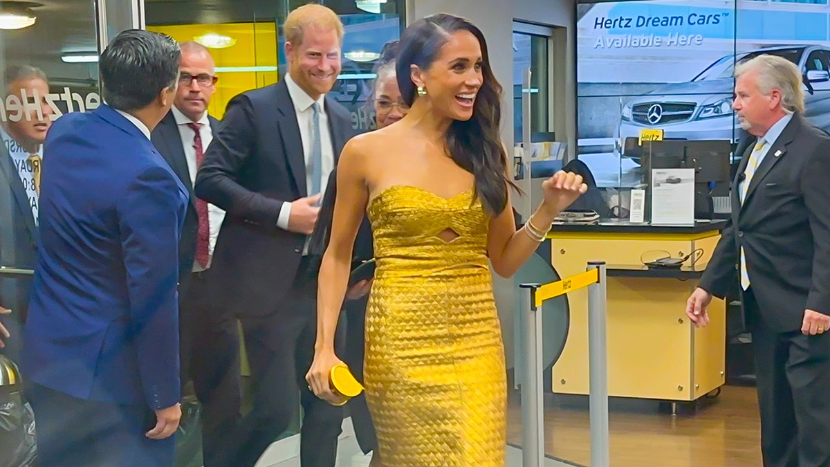 Meghan Markle wearing a gold dress arriving to the Women of Vision awards
