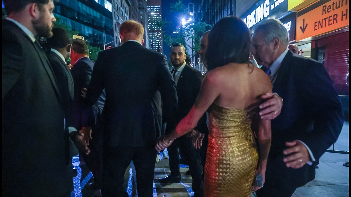 Meghan Markle and Prince Harry being escorted by security