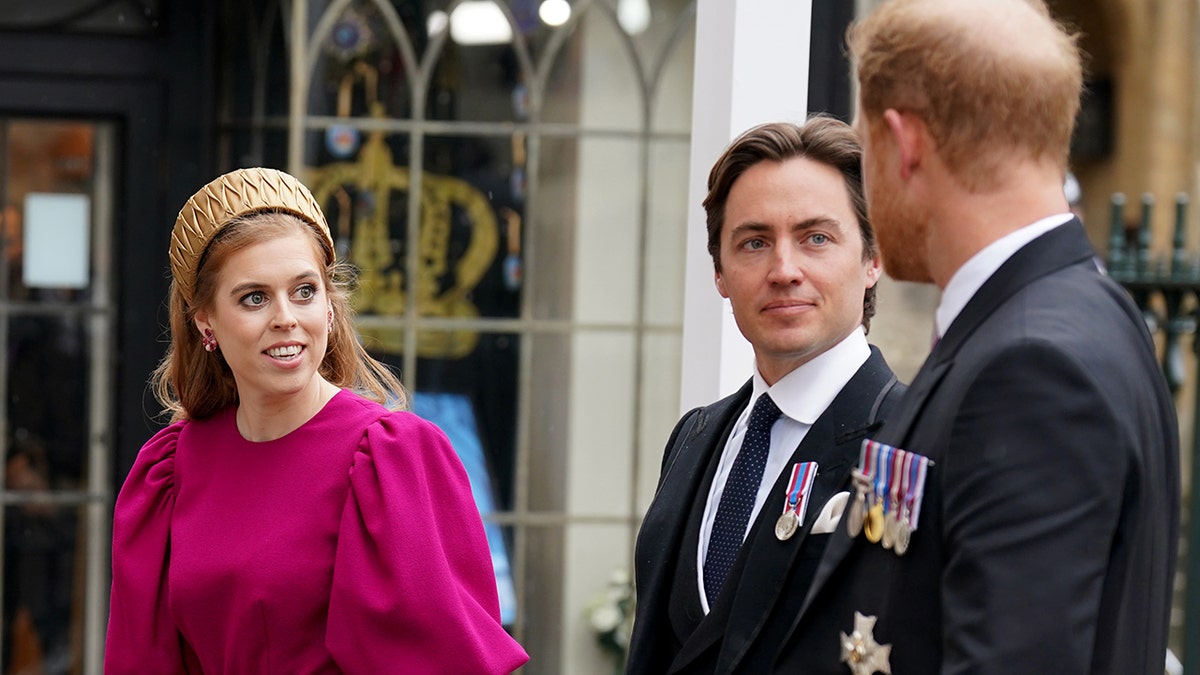 Prince Harry chatting with Princess Beatrice in a bright pink dress