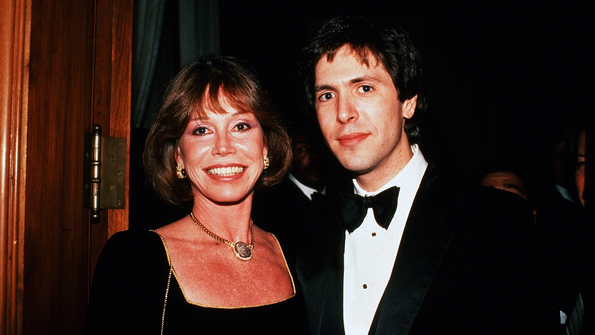 Mary Tyler Moore wearing a black dress next to Robert Levine wearing a tux