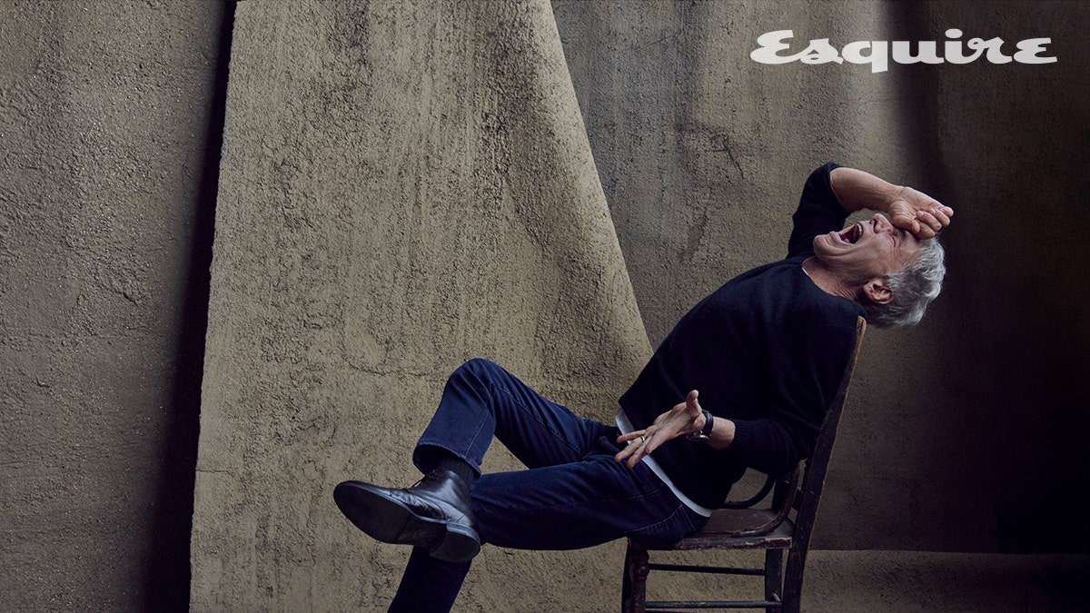 Harrison Ford sitting in a chair with his head back in a photo from Esquire
