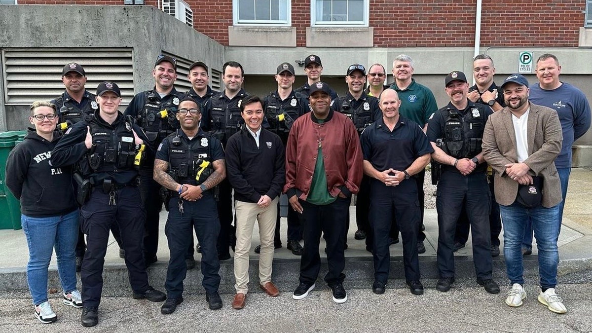 Kenan Thompson with Newport Governor Xay Khamsyvoravong center around police officers of the NPD