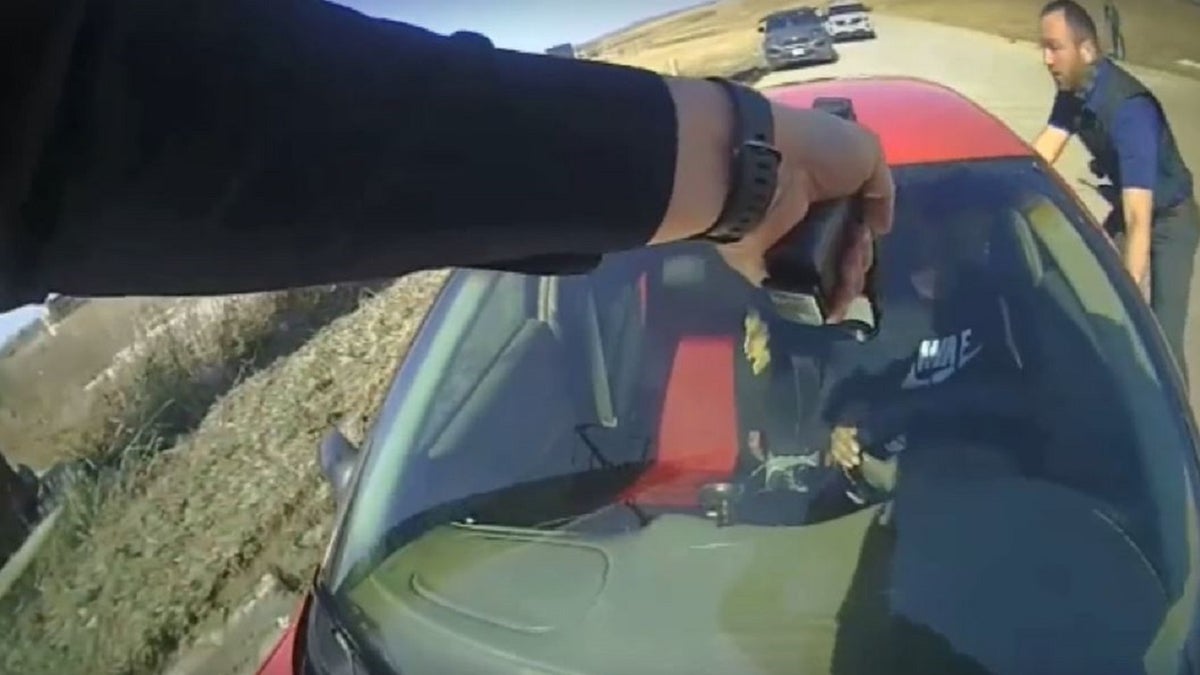 Cop on hood of car pointing gun at driver in Iowa