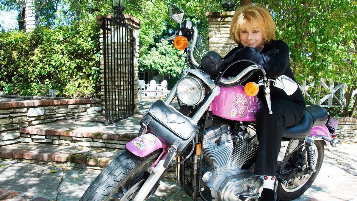 Ann-Margret sitting on her Harley-Davidson