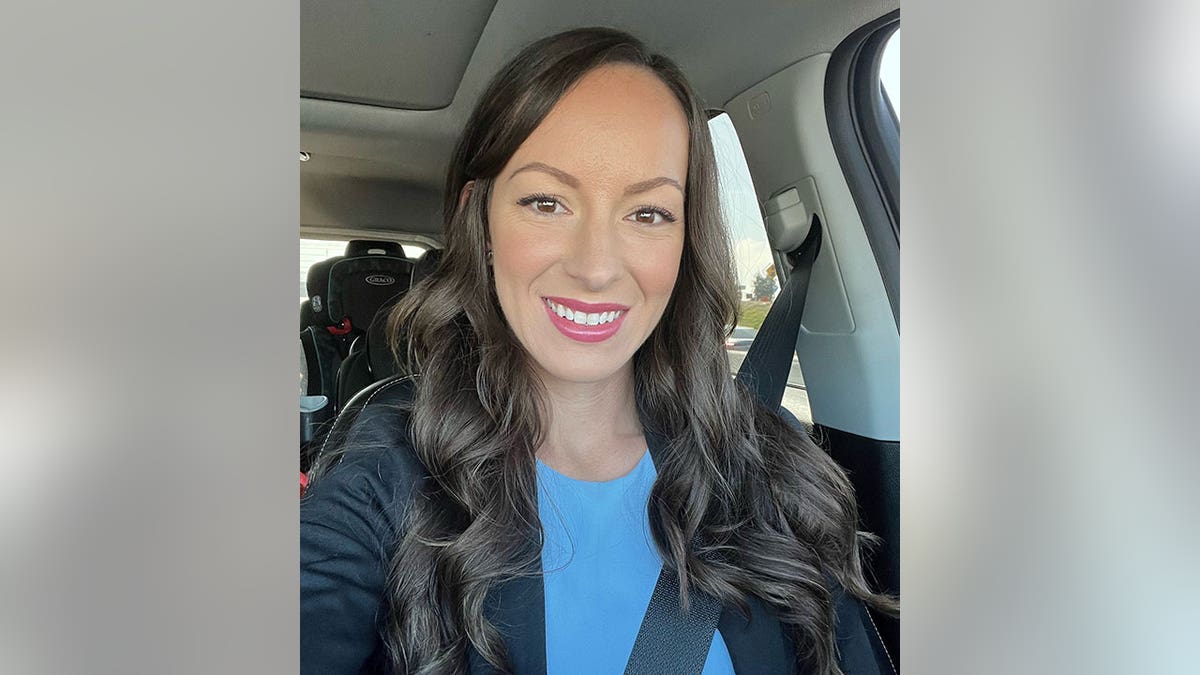 Jessica Tapia smiles in car selfie with child safety seat in the back