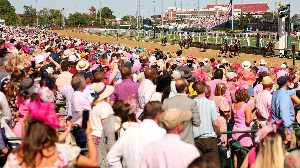 Spectators look on as horses finish