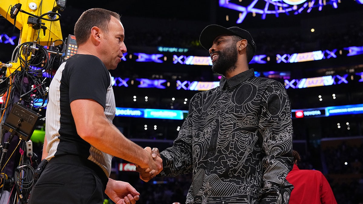 Referee Josh Tiven and Kyrie Irving shake hands