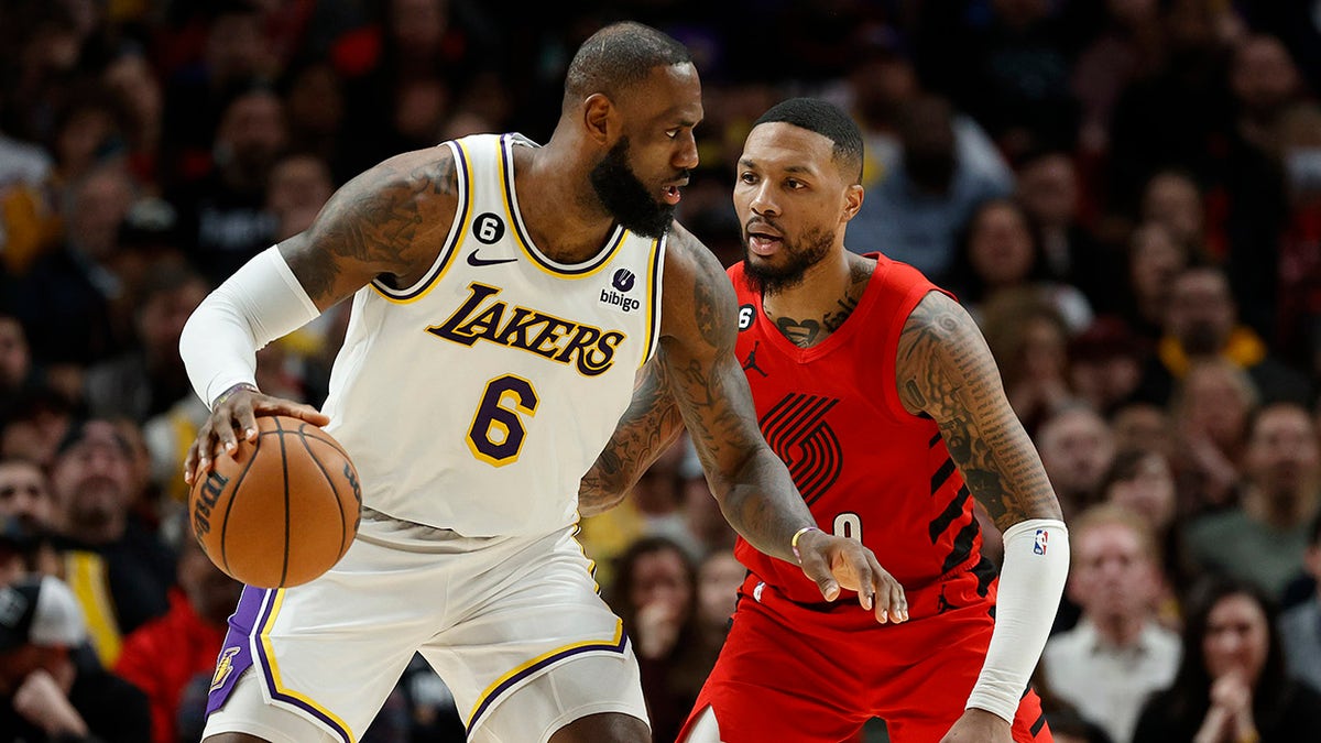 LeBron James dribbles against Damian Lillard